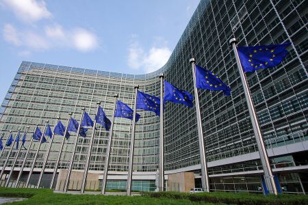 Das EU-Parlament mit EU-Flaggen davor.